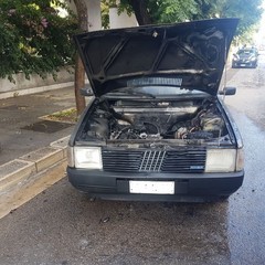 Fiamme dal vano motore di una Fiat Uno in piazza SS. Trinità
