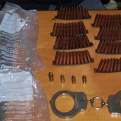 Munizioni e manette in una busta sotto un cumulo di sassi