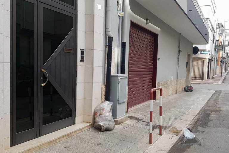 vie cittadine con buste dei rifiuti