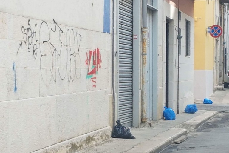 vie cittadine con buste dei rifiuti
