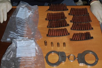 Munizioni e manette in una busta sotto un cumulo di sassi