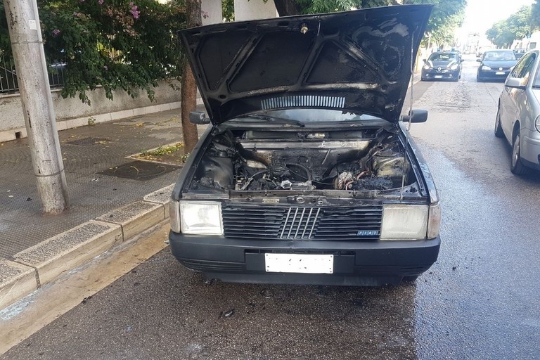 Fiamme dal vano motore di una Fiat Uno in piazza SS. Trinità